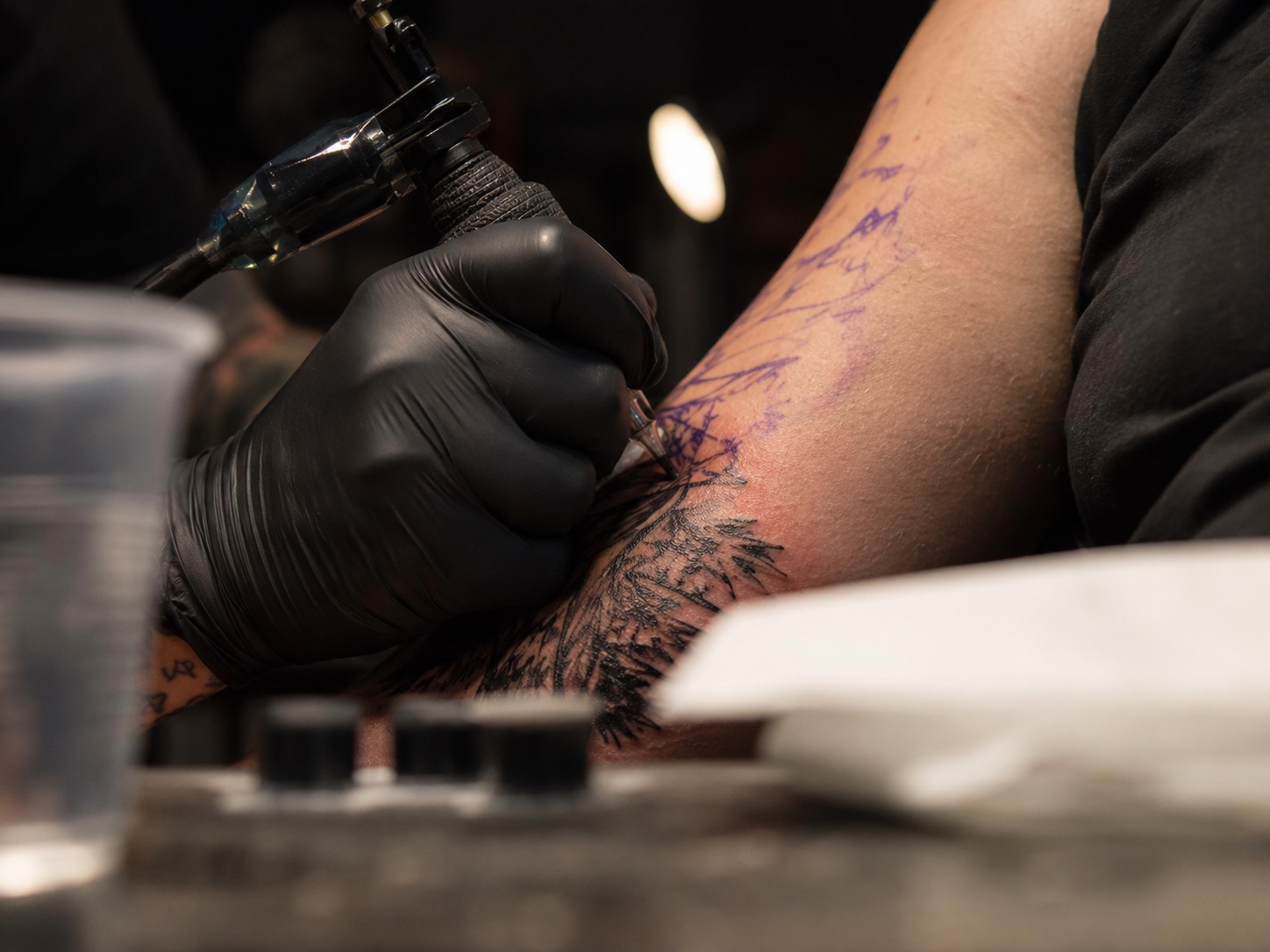 Tattoo machine at work on an upper arm